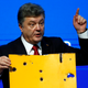 Ukrainian President Petro Poroshenko holds a fragment of a bus body which he says shows a Russian missile attack on a civilian bus as he addresses The Future of Ukraine event in the Swiss mountain resort of Davos January 21, 2015. More than 1,500 business leaders and 40 heads of state or government will attend the Jan. 21-24 meeting of the World Economic Forum (WEF) to network and discuss big themes, from the price of oil to the future of the Internet. This year they are meeting in the midst of upheaval, with security forces on heightened alert after attacks in Paris, the European Central Bank considering a radical government bond-buying programme and the safe-haven Swiss franc rocketing.